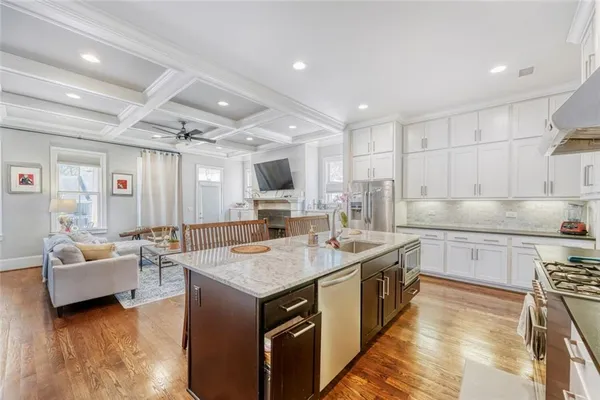 a large kitchen with kitchen island a large counter top space a sink stainless steel appliances and cabinets