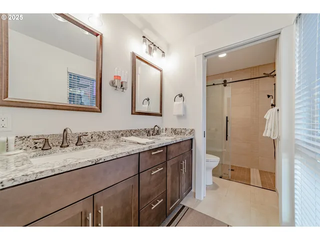 a bathroom with a granite countertop sink mirror toilet and shower