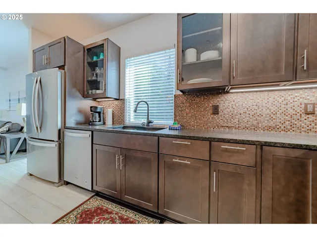 a kitchen with stainless steel appliances granite countertop a refrigerator and a sink