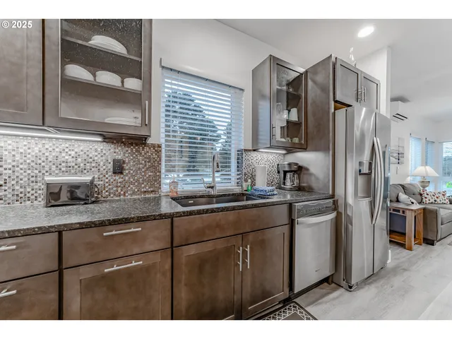 a kitchen with stainless steel appliances granite countertop a sink stove and refrigerator