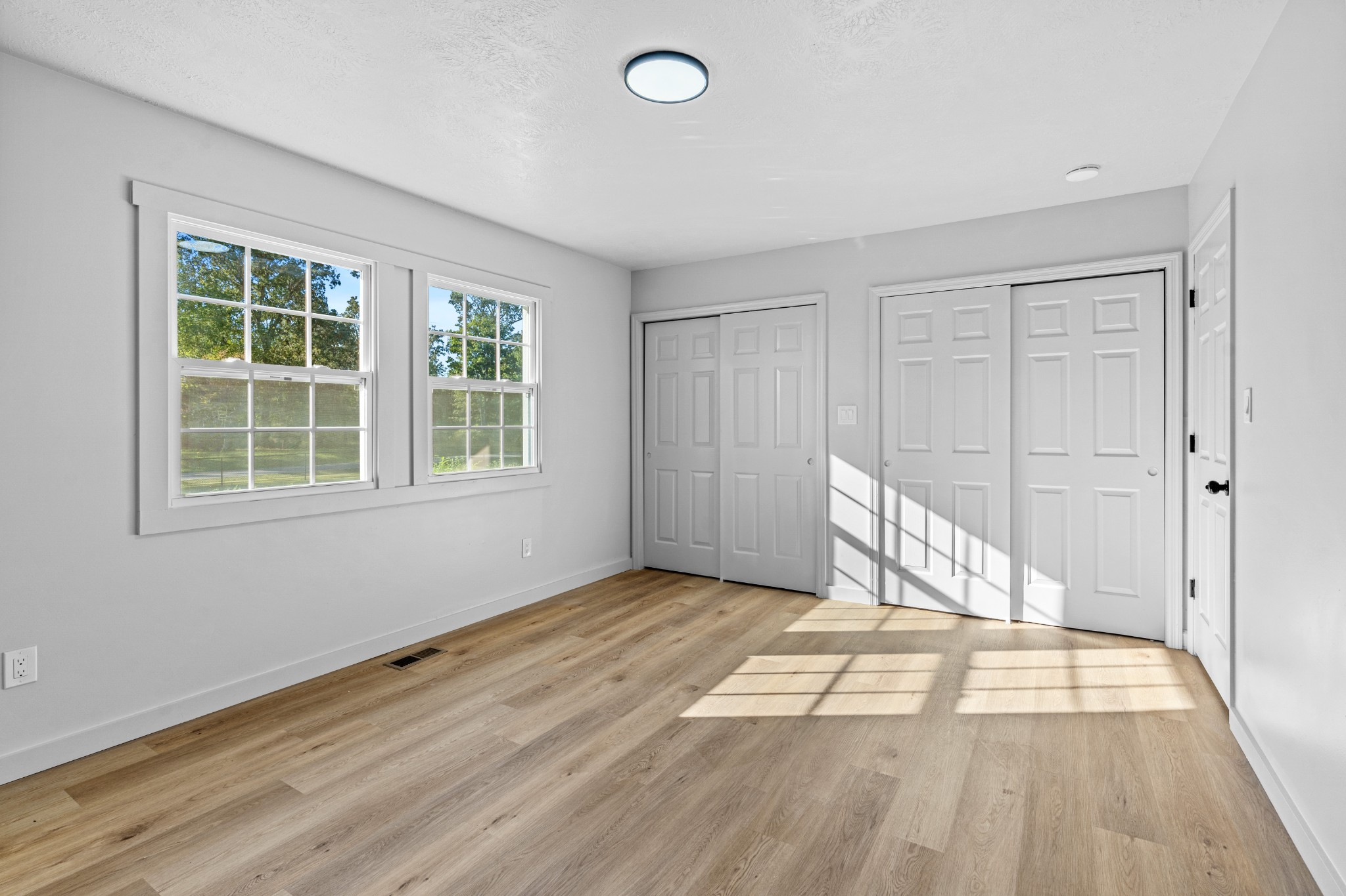 191 Blanton Chapel Road Manchester, TN 37355 - Photo 12 of 26 an empty room with wooden floor and windows