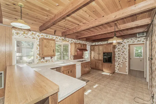 a large kitchen with kitchen island a stove a sink dishwasher and white cabinets