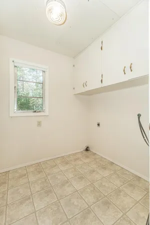 a view of a kitchen with white cabinets and a window
