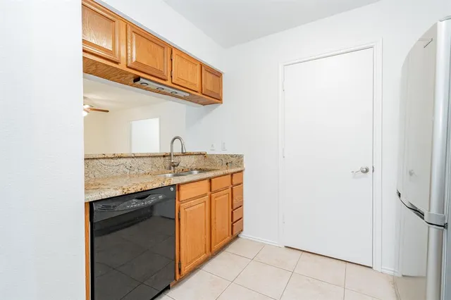 a kitchen with stainless steel appliances granite countertop a sink and a refrigerator