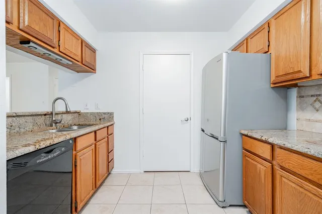 a kitchen with stainless steel appliances granite countertop a sink and a refrigerator