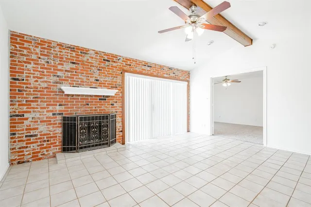 a view of an empty room with chandelier fan