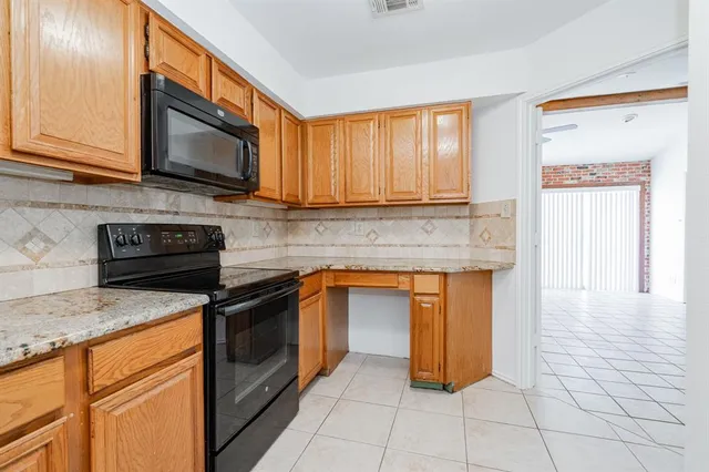 a kitchen with stainless steel appliances granite countertop a stove top oven microwave and cabinets