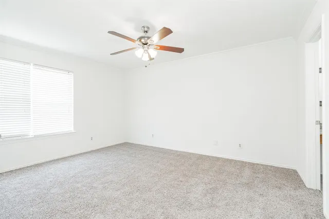 an empty room with a window and a fan