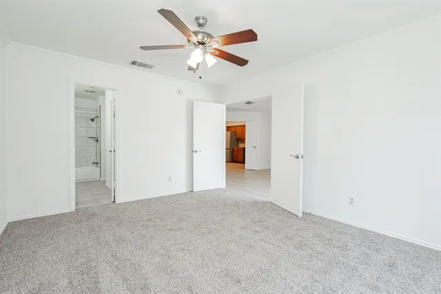 an empty room with closet and a ceiling fan