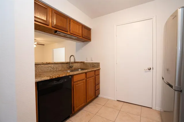 a kitchen with stainless steel appliances granite countertop a sink and a refrigerator