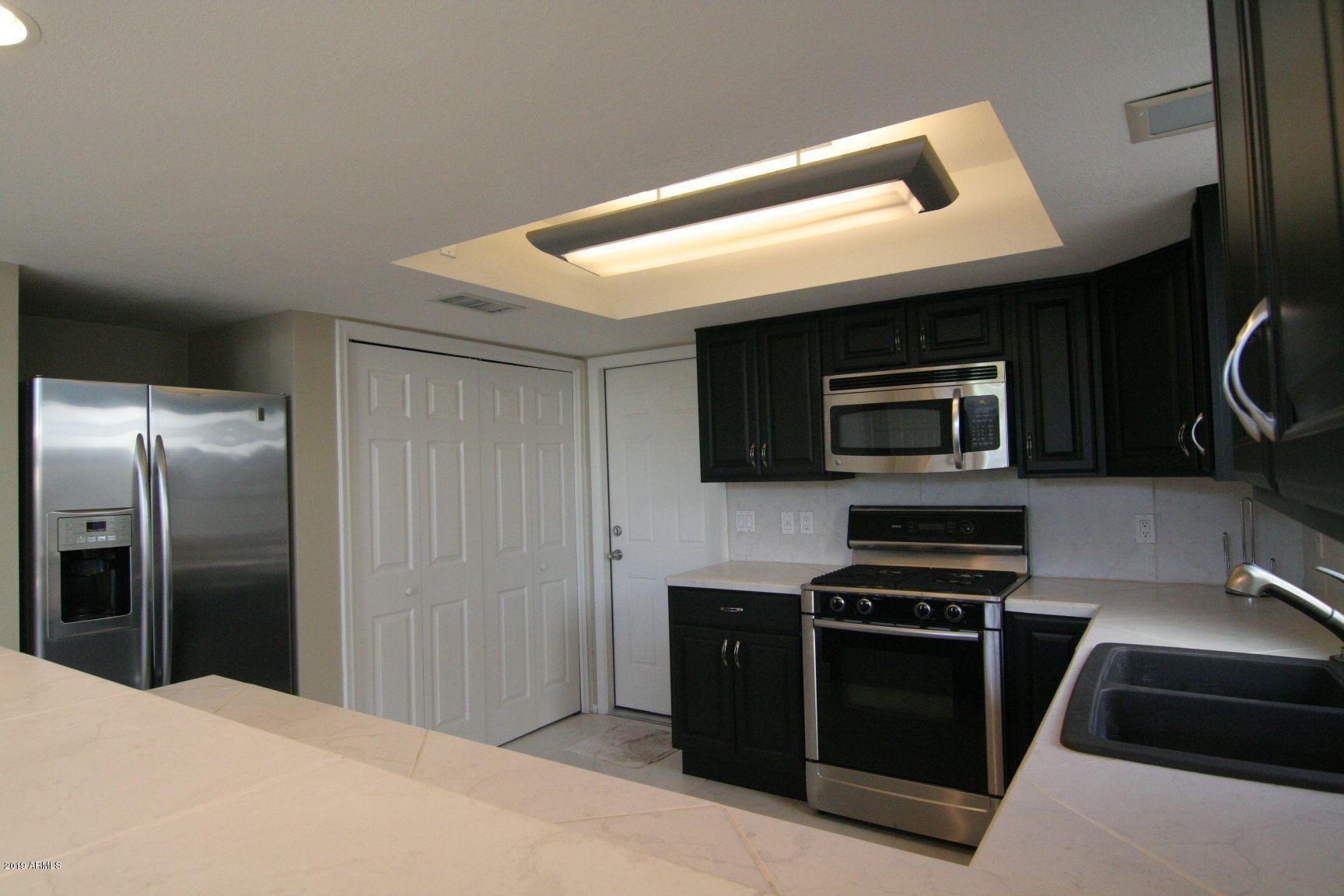 136 West Victoria Square Phoenix, AZ 85013 - Photo 4 of 15 a kitchen with stainless steel appliances a stove a microwave and a refrigerator