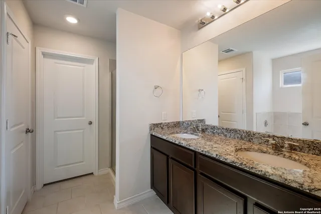 a bathroom with a granite countertop sink and a mirror