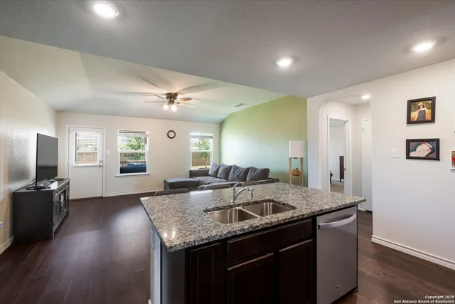 a kitchen with granite countertop kitchen island a sink appliances and a counter top