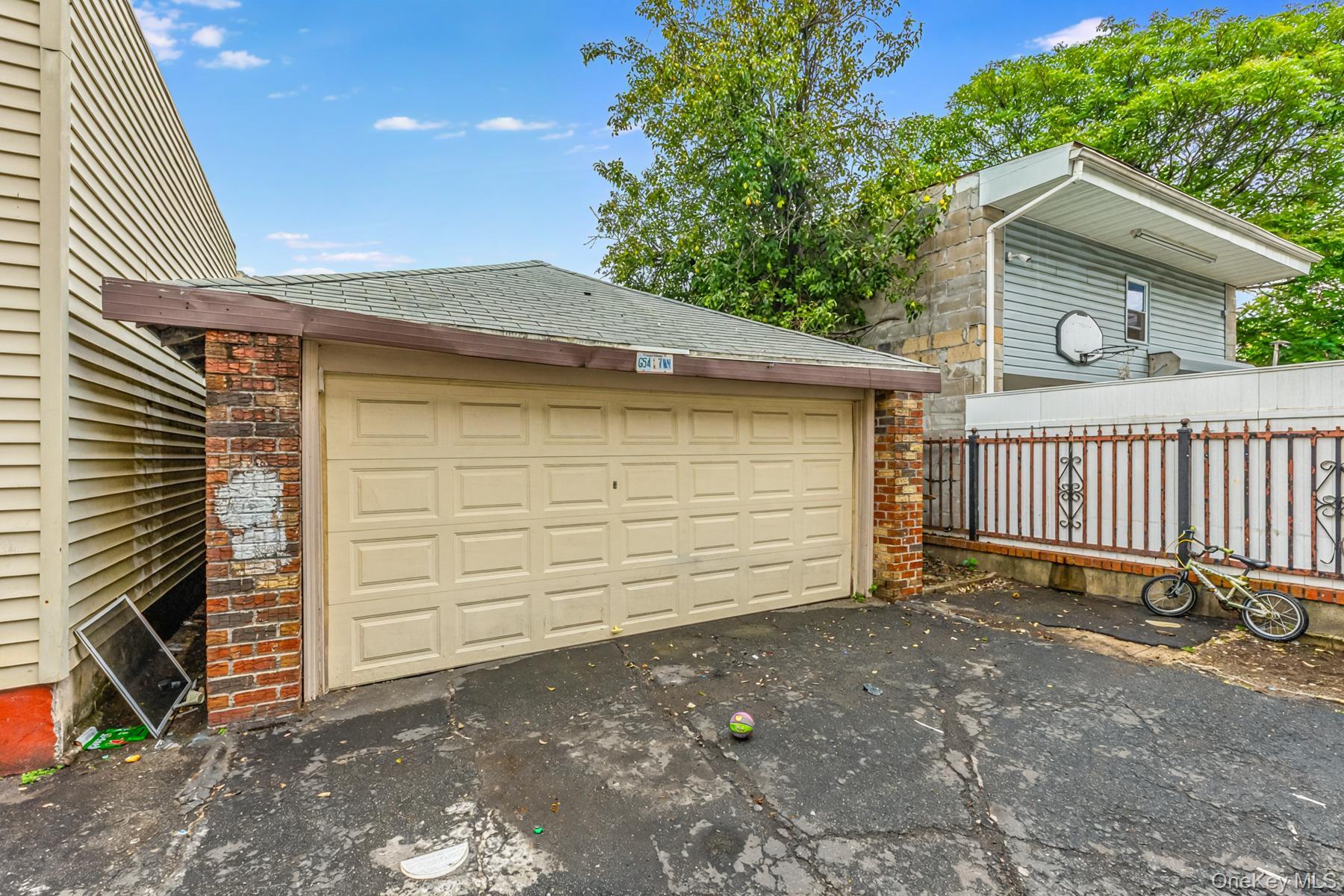 37-33 100th Street Queens, NY 11368 - Photo 13 of 14 Garage featuring asphalt driveway
