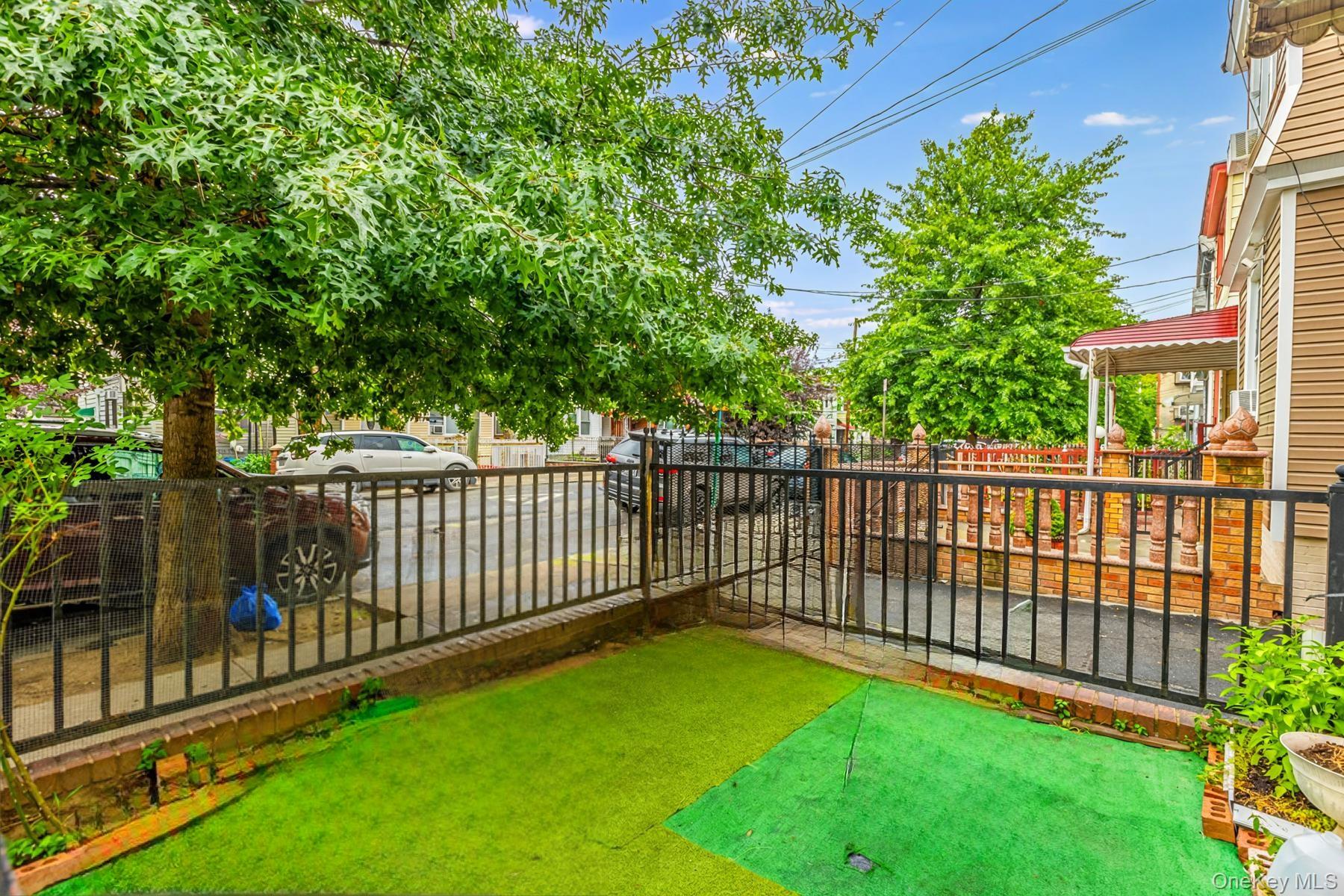 37-33 100th Street Queens, NY 11368 - Photo 2 of 14 Fenced backyard featuring an area to practice putting