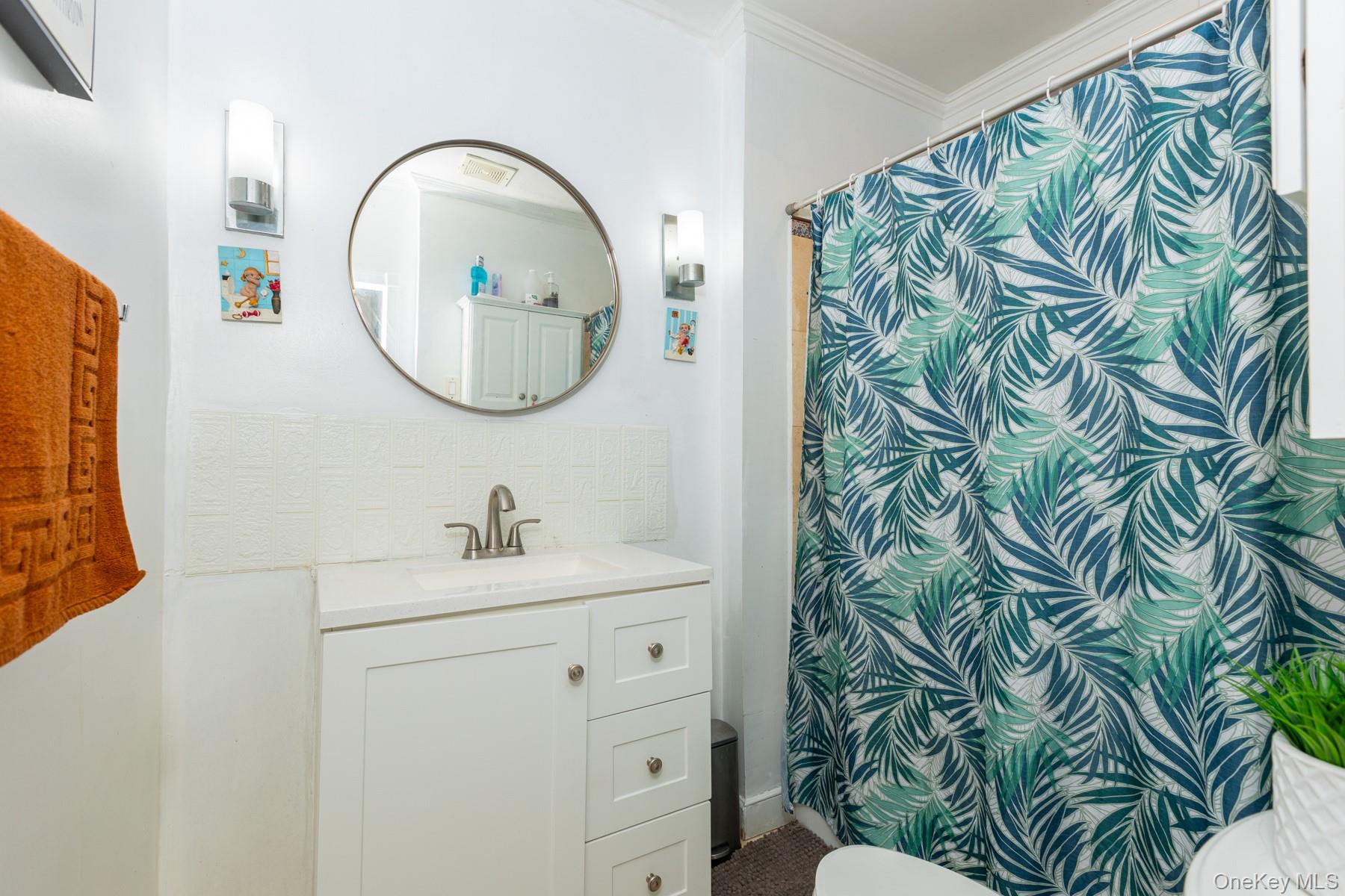 37-33 100th Street Queens, NY 11368 - Photo 4 of 14 Full bathroom with vanity, crown molding, tasteful backsplash, and a shower with curtain