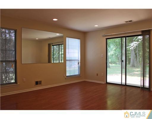 2001 Timber Oaks Road Edison, NJ 08820 - Photo 2 of 25 a view of an empty room with wooden floor and a window