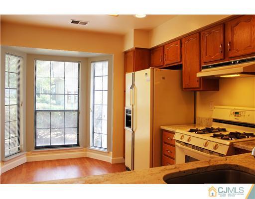 2001 Timber Oaks Road Edison, NJ 08820 - Photo 4 of 25 a kitchen with stainless steel appliances granite countertop a refrigerator a stove and a sink with wooden cabinets