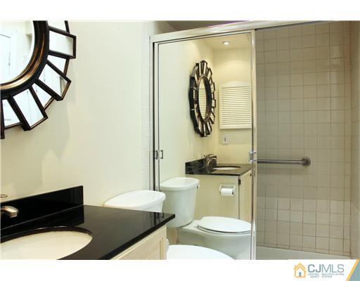 2001 Timber Oaks Road Edison, NJ 08820 - Photo 6 of 25 a bathroom with a toilet a sink and mirror