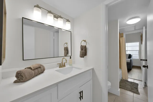 a en suite bathroom with a double vanity sink and a mirror