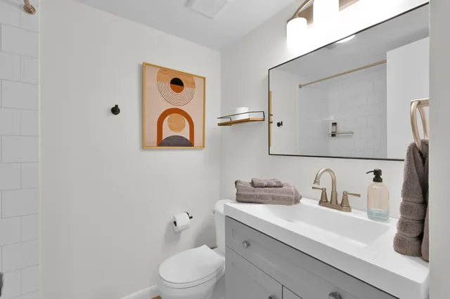 a bathroom with a toilet sink and mirror