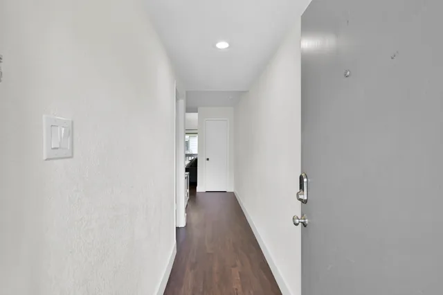 a view of a hallway with wooden floor