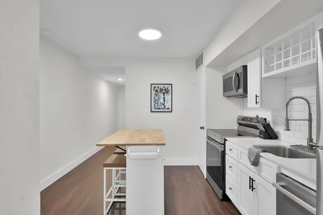 a kitchen with stainless steel appliances a sink stove and refrigerator