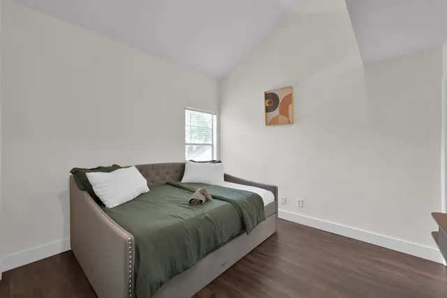 a bed sitting in a bedroom next to a window