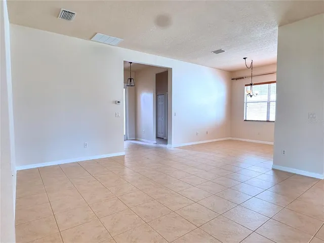 an empty room with windows and chandelier