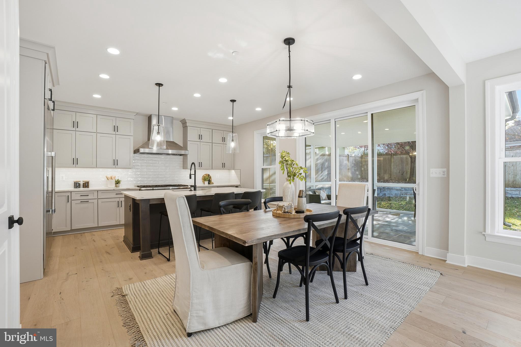 8802 Ridge Road Bethesda, MD 20817 - Photo 11 of 26 a kitchen with stainless steel appliances kitchen island granite countertop a table chairs and a wooden floor