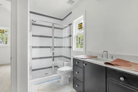 a bathroom with a granite countertop sink mirror vanity and a bathtub