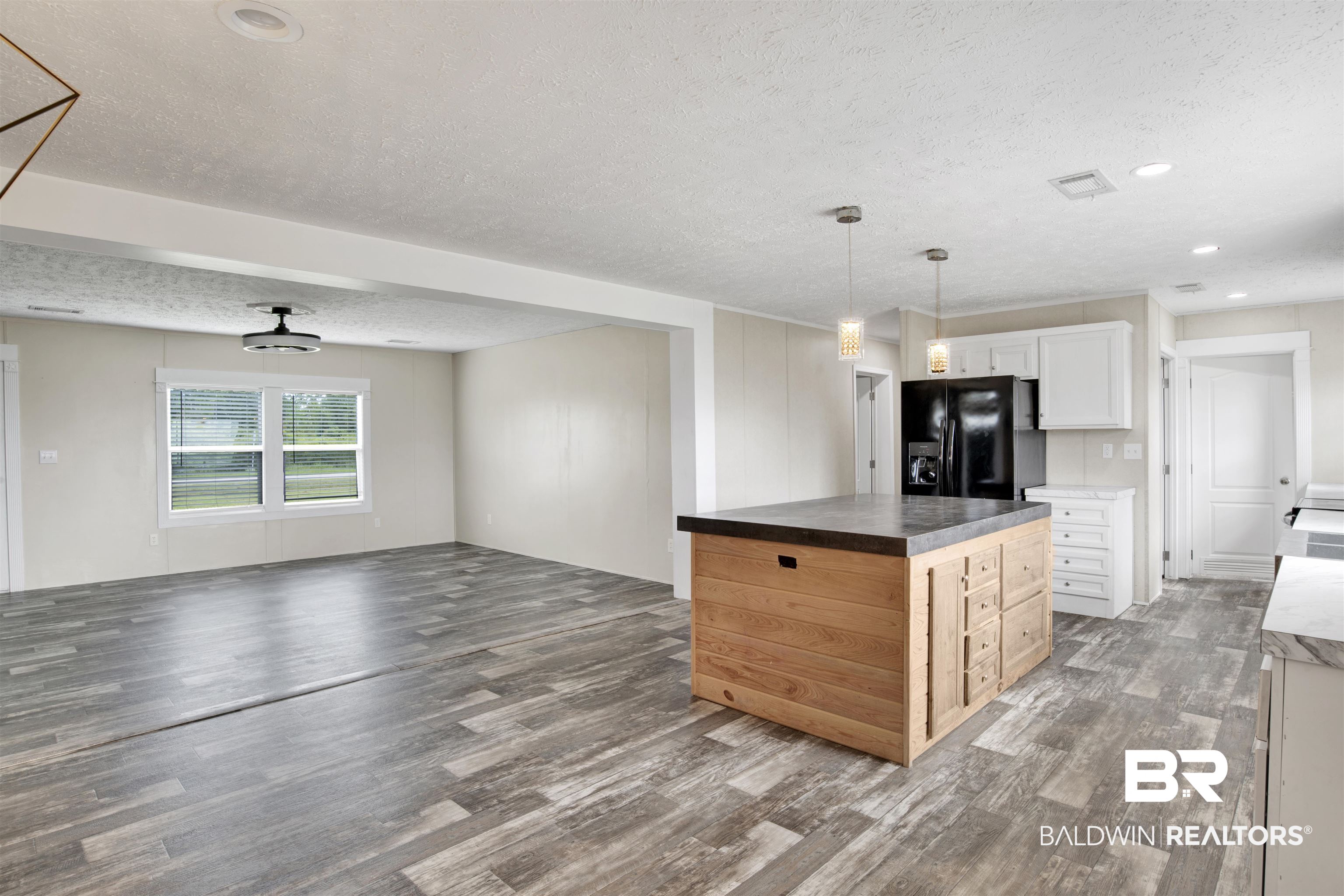 16778 County Road 87 Elberta, AL 36530 - Photo 14 of 32 Kitchen featuring a kitchen island, dark hardwood / wood-style floors, black fridge with ice dispenser, a textured ceiling, and white cabinetry