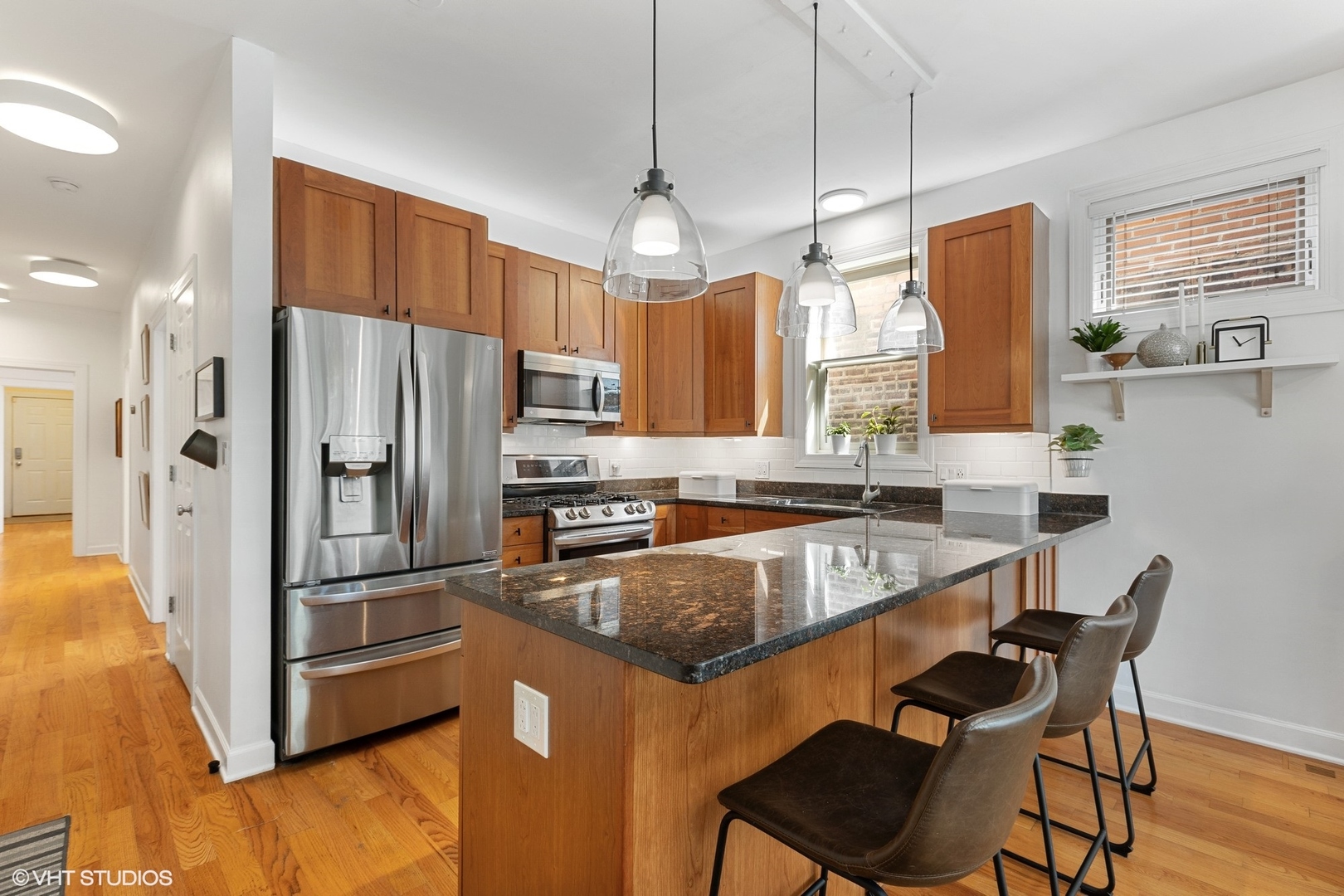 1512 West Victoria Street, Unit 2 Chicago, IL 60660 - Photo 10 of 19 a kitchen with stainless steel appliances granite countertop a refrigerator a stove a sink dishwasher a dining table and chairs with wooden floor