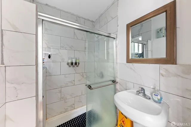 a bathroom with a sink shower and a mirror