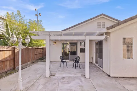 a view of a patio with table and chairs with a large tree