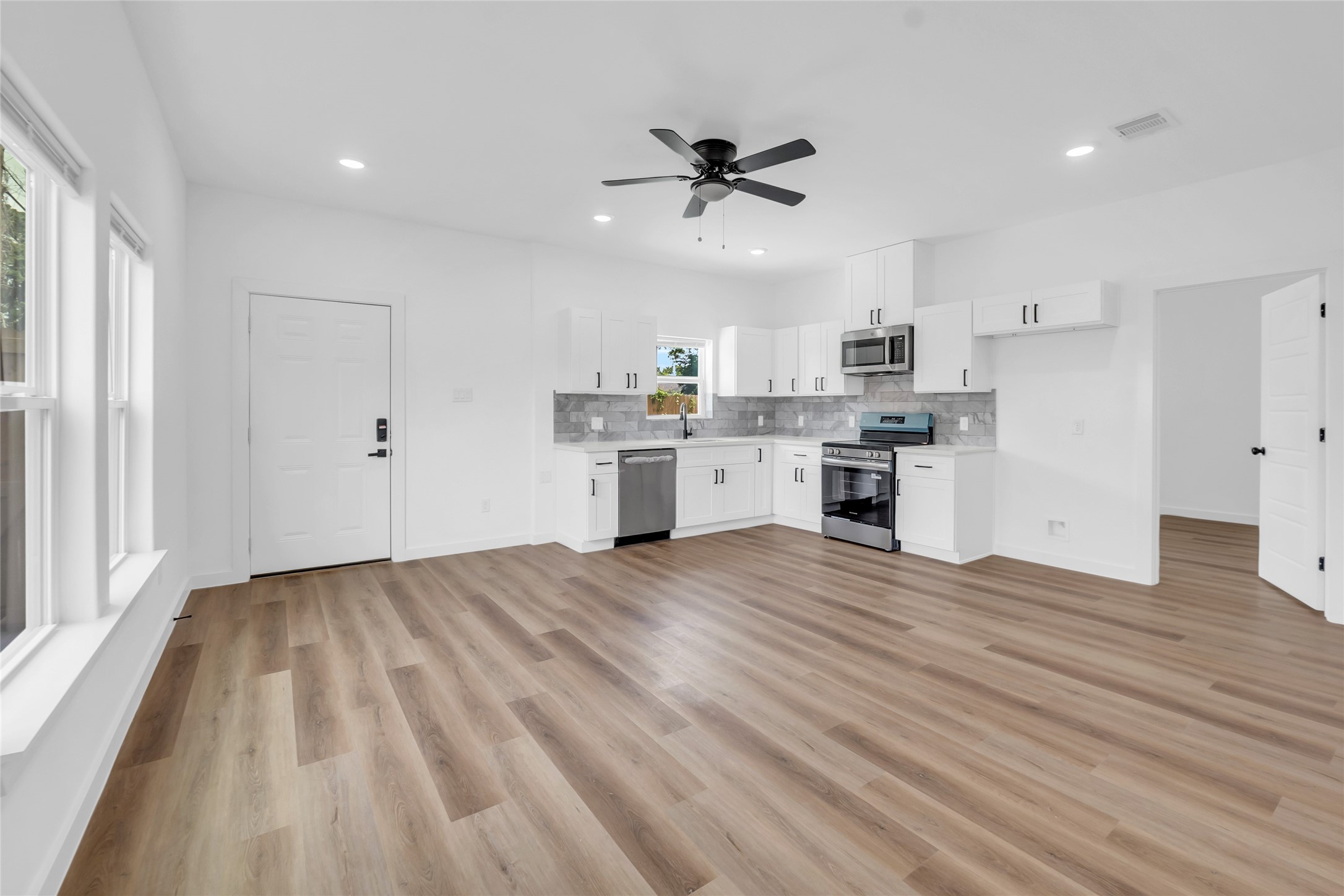 9818 Sandra Street, Unit B Houston, TX 77016 - Photo 2 of 19 a view of a kitchen with kitchen island wooden floors appliances and cabinets