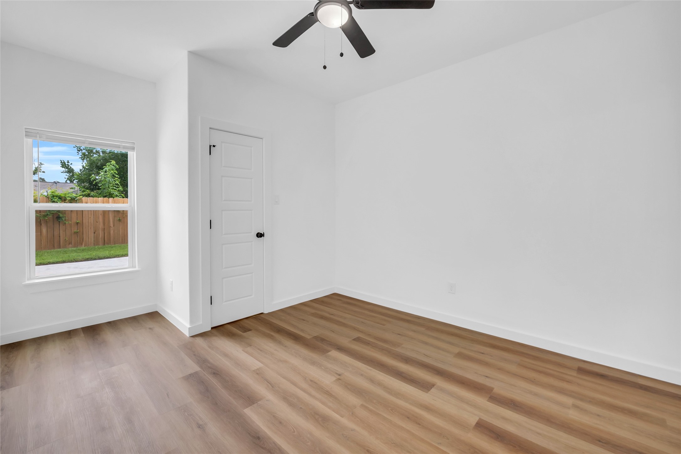 9818 Sandra Street, Unit B Houston, TX 77016 - Photo 9 of 19 wooden floor in an empty room with a window
