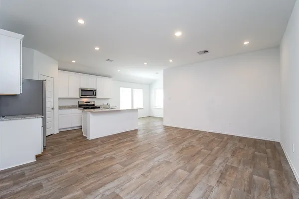 a view of kitchen with refrigerator sink and white cabinets