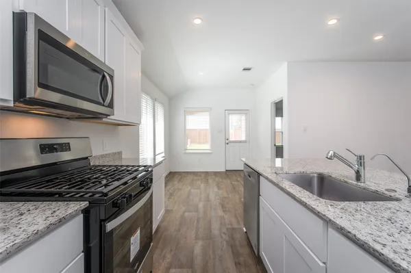 a stove top oven sitting inside of a kitchen