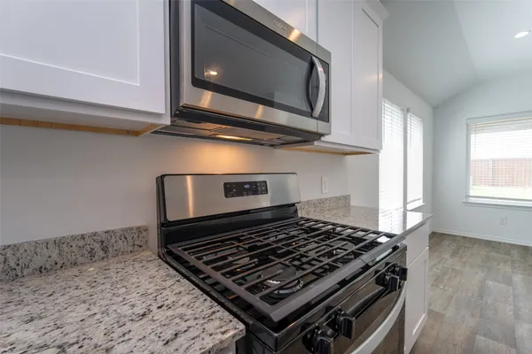 a kitchen with stainless steel appliances granite countertop a sink a refrigerator and a granite counter tops