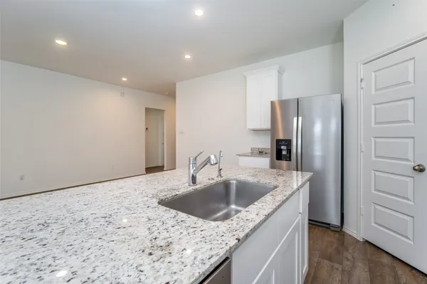 a view of kitchen with kitchen island wooden floor center island and stainless steel appliances