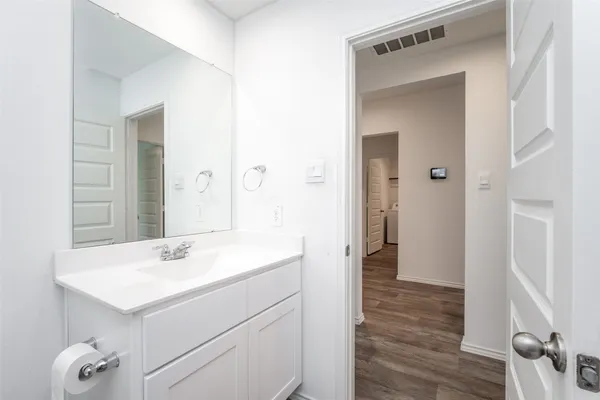 a view of kitchen with granite countertop refrigerator oven a sink and white cabinets with wooden floor