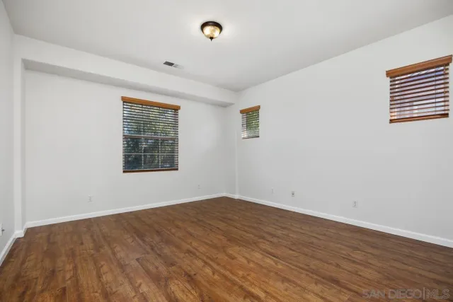 a view of a house with a small yard and wooden fence