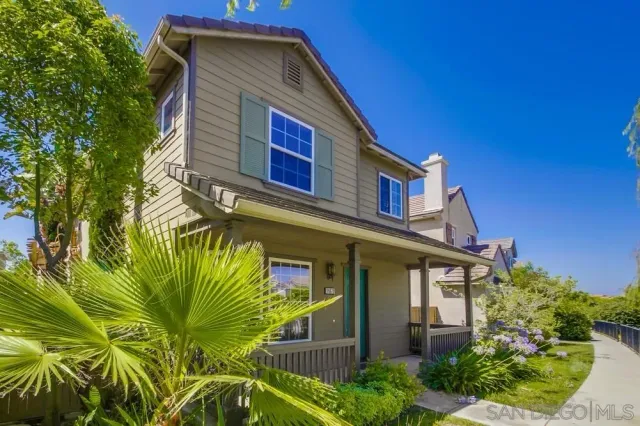 a view of an empty room with wooden floor fireplace and a window