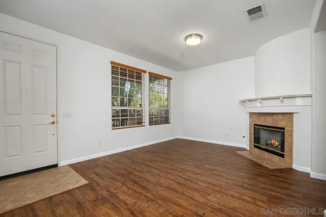 a view of a room with wooden floor and a window