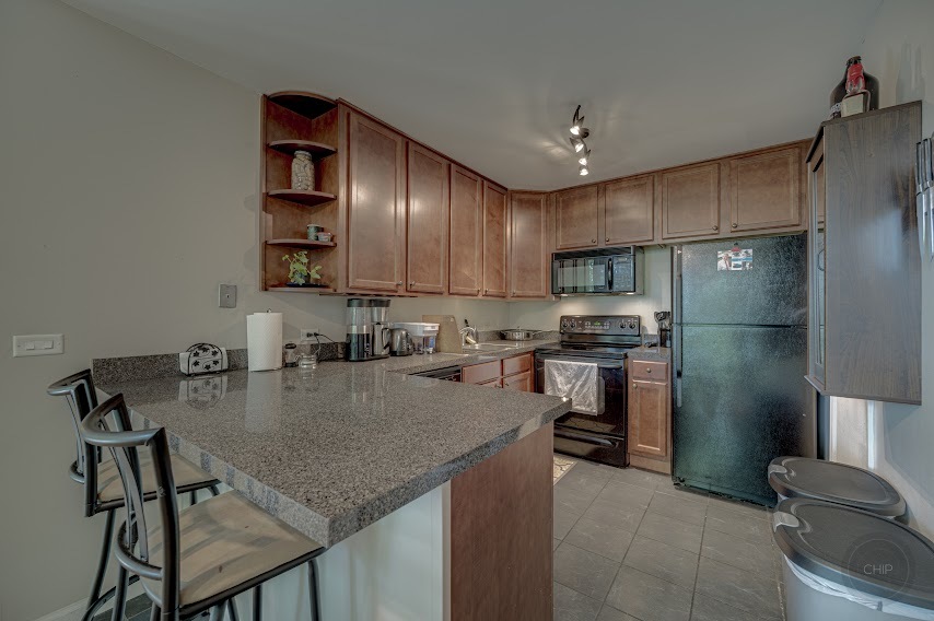 5904 Forest View Road, Unit 2F Lisle, IL 60532 - Photo 11 of 28 a kitchen with kitchen island a counter top space appliances and cabinets