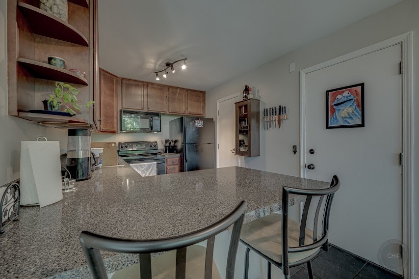 5904 Forest View Road, Unit 2F Lisle, IL 60532 - Photo 12 of 28 a kitchen with stainless steel appliances granite countertop a kitchen island a stove a dining table and chairs