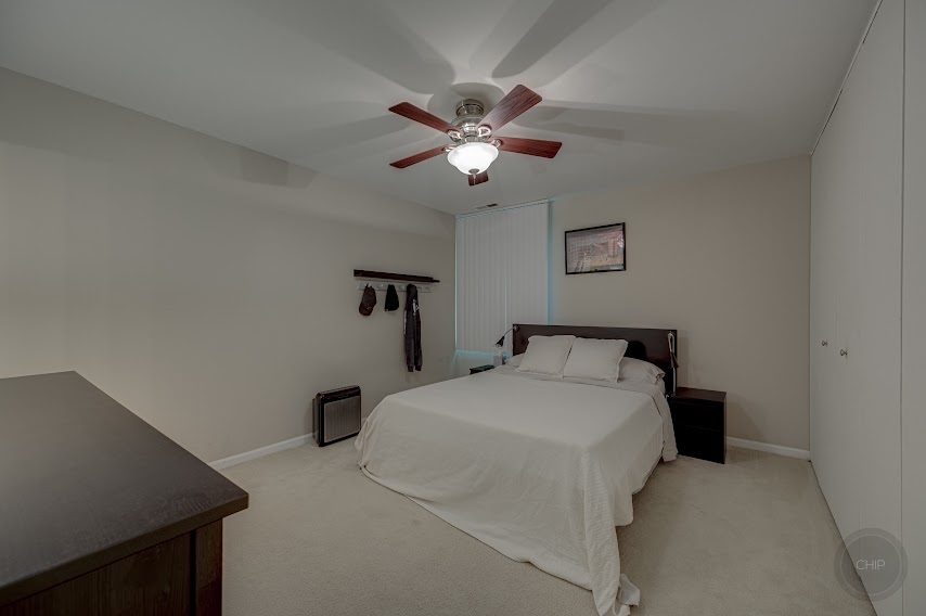 5904 Forest View Road, Unit 2F Lisle, IL 60532 - Photo 15 of 28 a bedroom with a bed and a chandelier