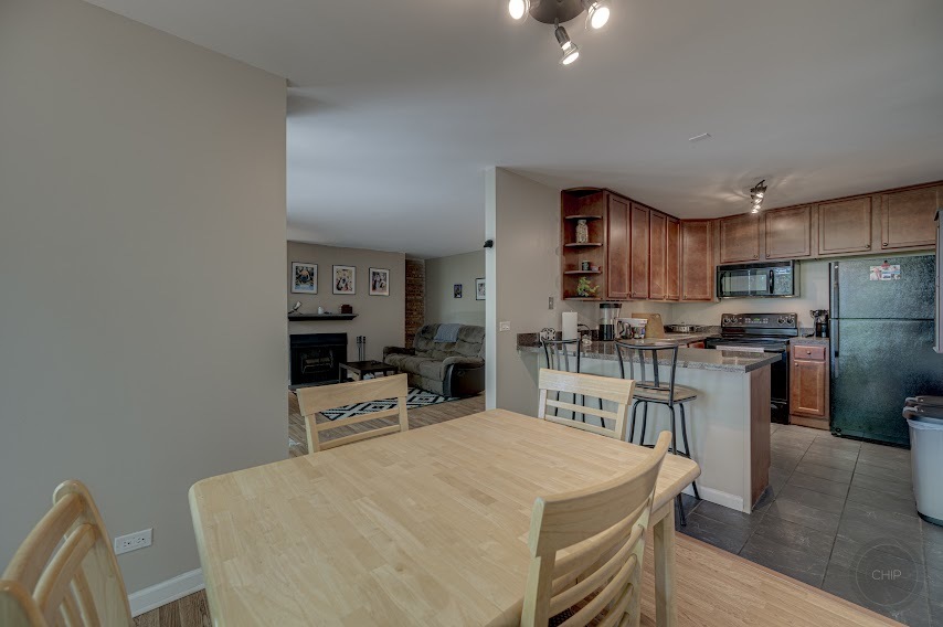 5904 Forest View Road, Unit 2F Lisle, IL 60532 - Photo 9 of 28 a kitchen with a table chairs refrigerator and microwave