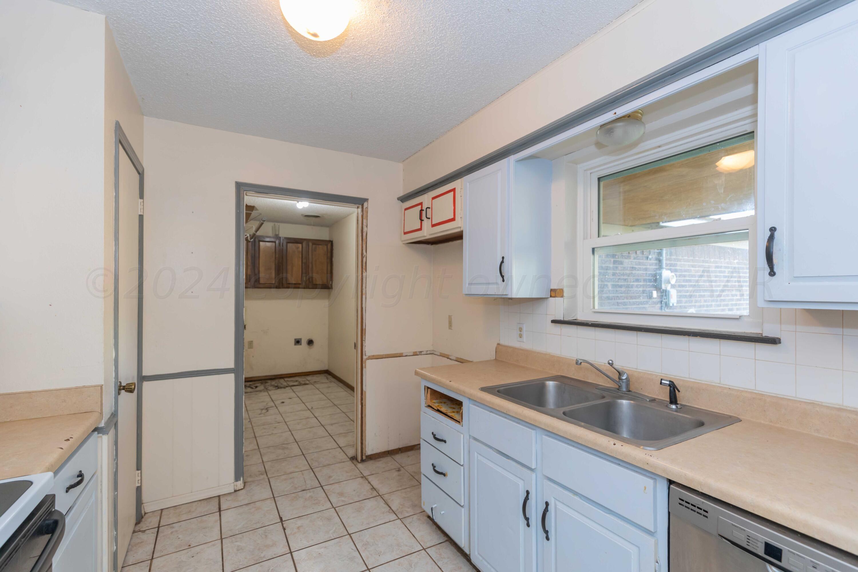 5304 Leigh Avenue Amarillo, TX 79110 - Photo 21 of 36 a kitchen with a sink cabinets and window